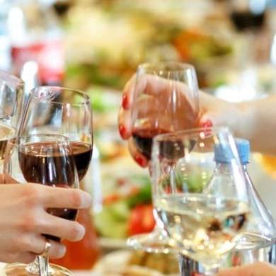a person sitting at a table with wine glasses